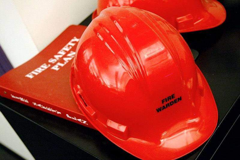 Top view of red fire warden hat on a desk