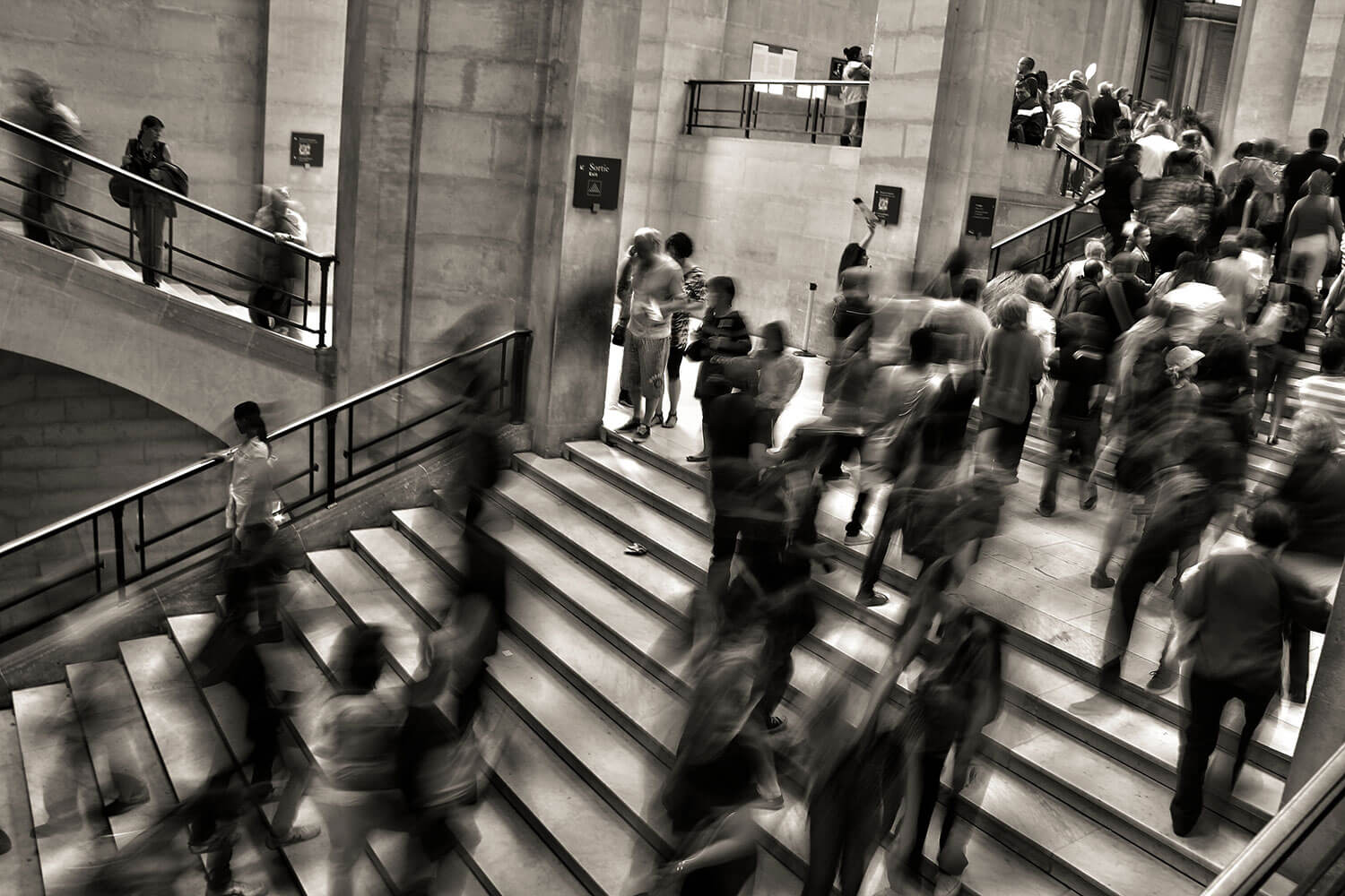 sepia image of people in suits walking up and down stairs