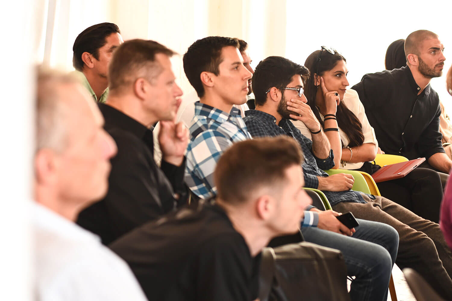 a crowd of people sitting and looking to the right of screen